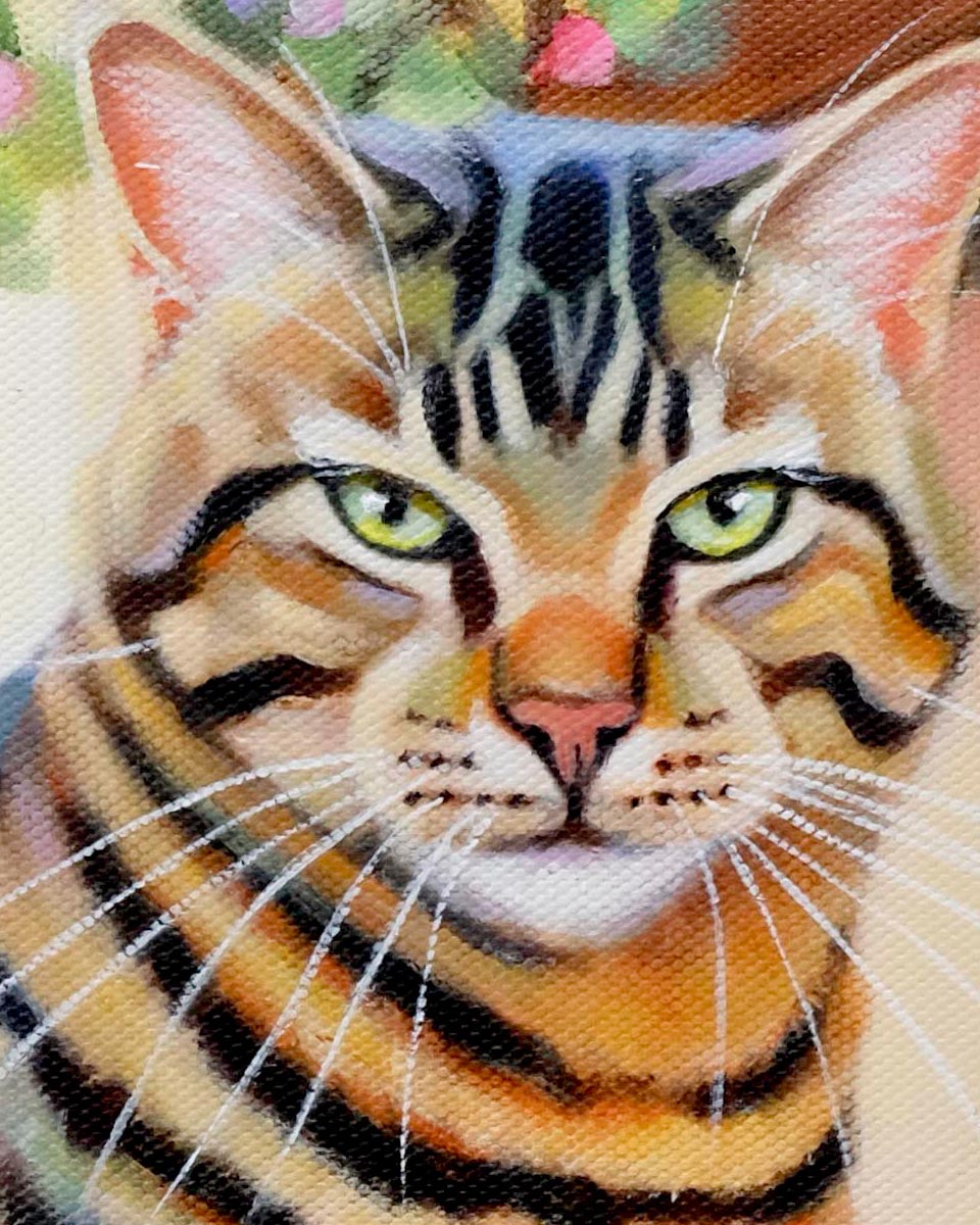 close up of a painting of a tabby cat on canvas showing his green eyes and tiger stripes.