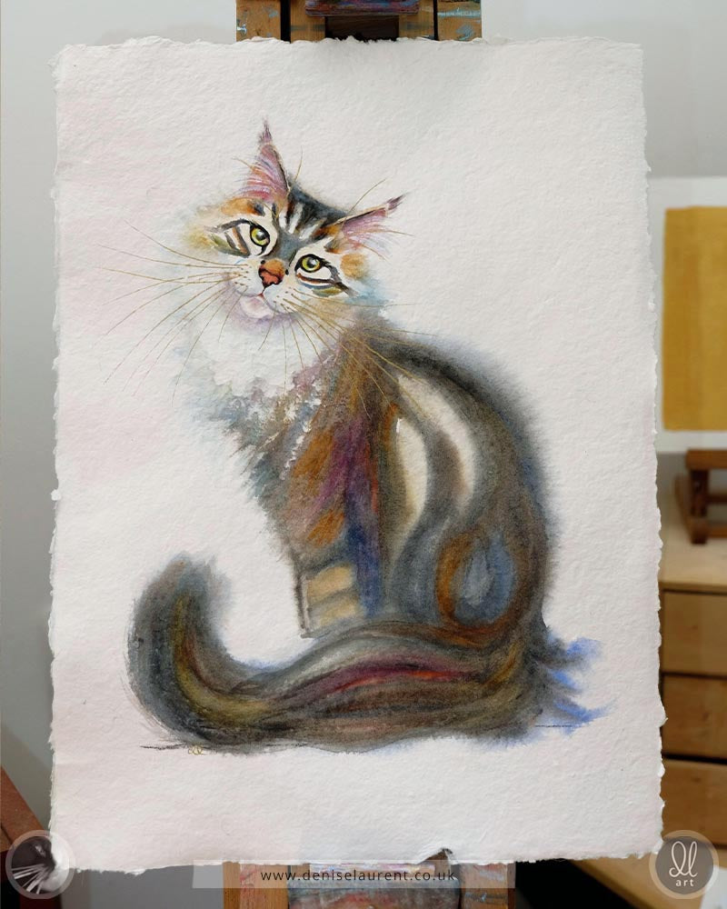 a long haired tabby cat watercolour painting on handmade paper sitting on the easel showing the four deckle edges of the paper.