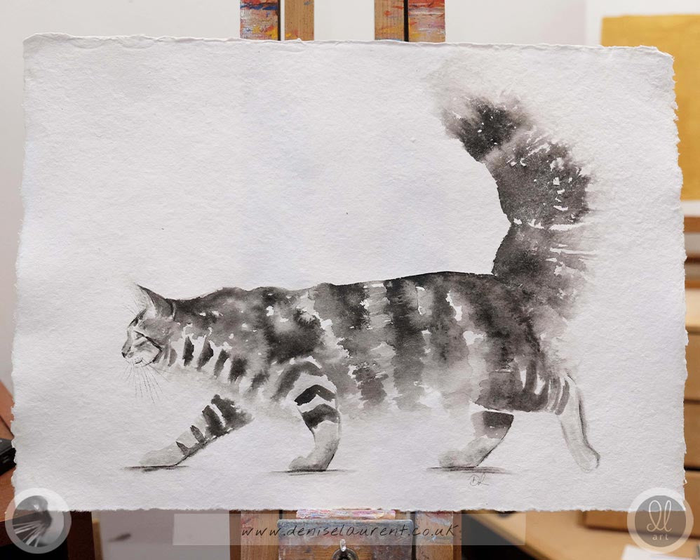 a watercolour painting of a maine coon cat on handmade paper, on the easel, showing the 4 deckle edges.