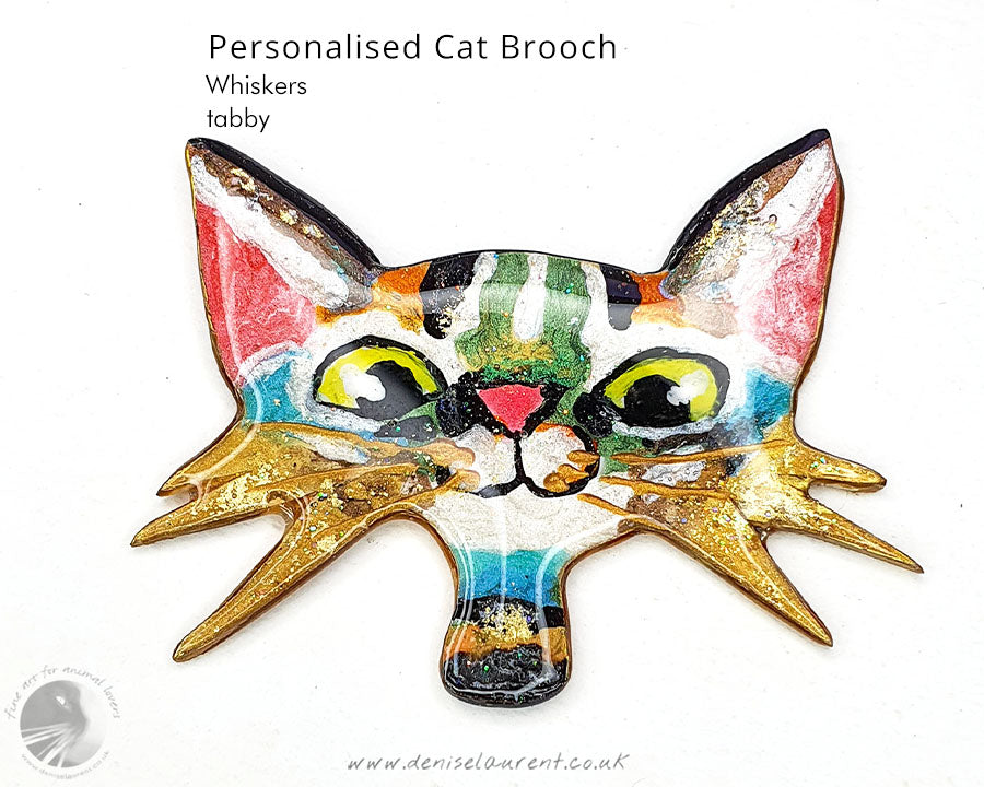Custom cat brooch featuring a vibrant tabby cat face with playful colours and whiskers, perfect for animal lovers.