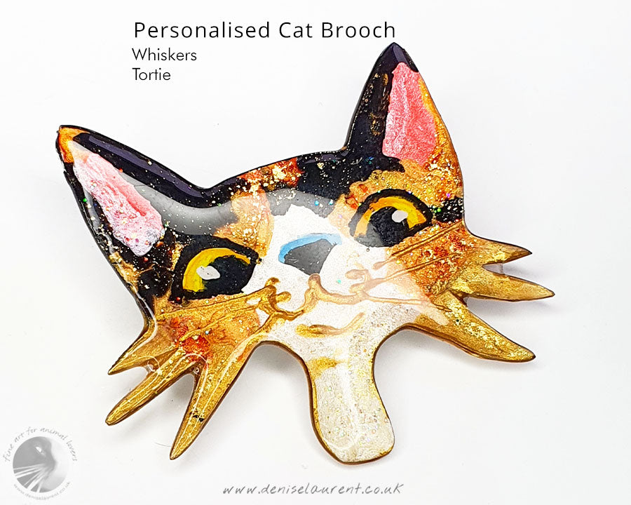Custom cat brooch displaying a tortie cat face with whimsical features, a great addition for cat lovers.