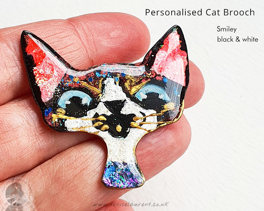 Custom cat brooch showcasing a striking black and white smiley cat design, perfect for cat enthusiasts.