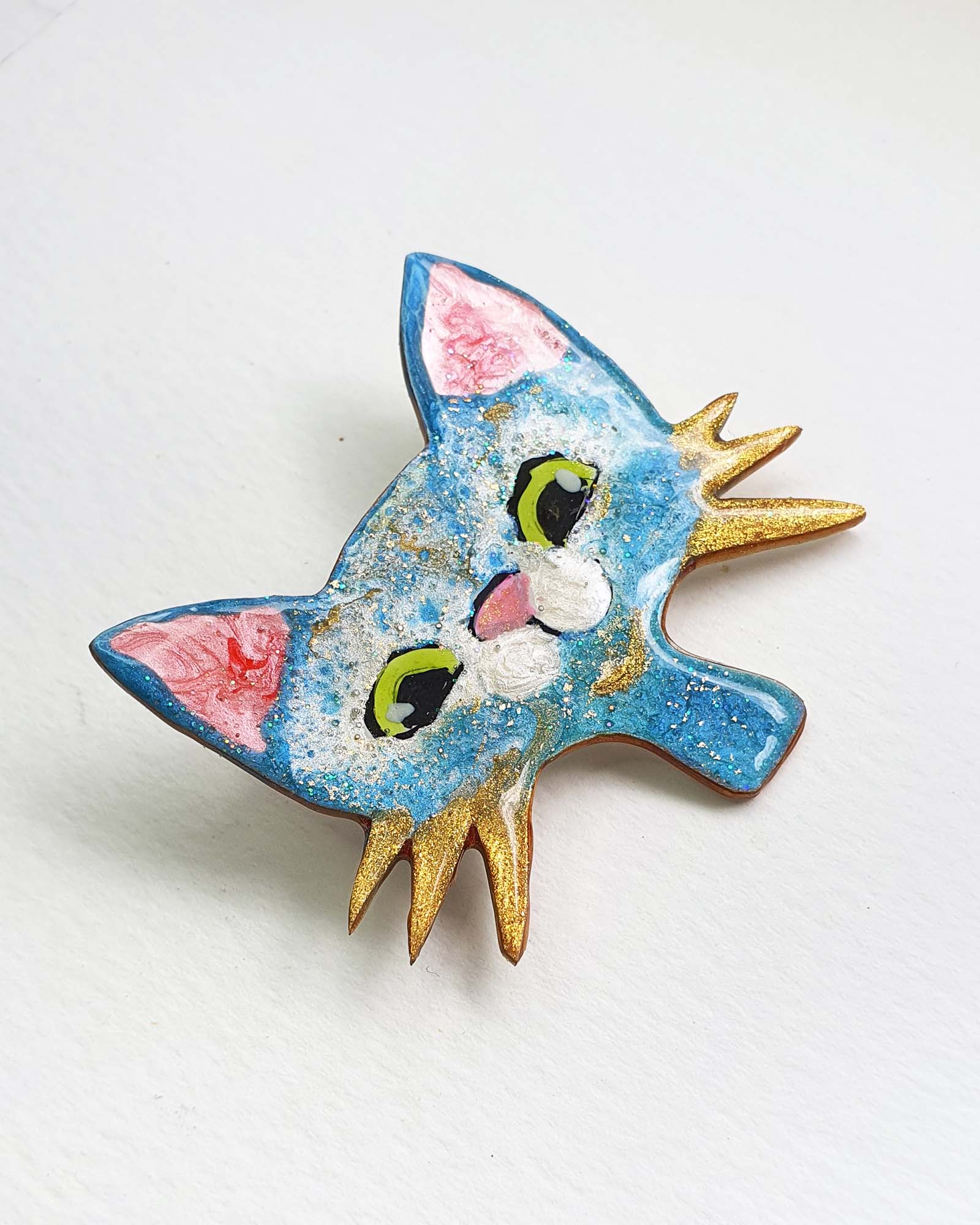 A unique handmade cat brooch from my catitude series.  She is a blue cat with green eyes, a cute pink nose and gold whiskers. A whimsical, fun cat face brooch.