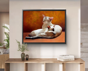 Siamese cat framed canvas wall art, 2 siamese cats curled up together on an orange sofa, hanging in a contemporary hallway.