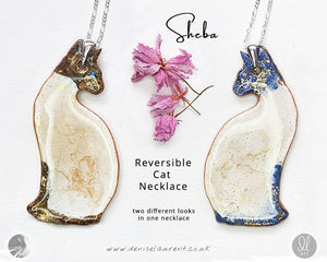 a siamese cat double sided necklace with a chocolate point on one side and a blue point siamese cat on the other