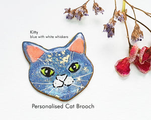 Custom cat brooch depicting a cute blue cat with white whiskers, brilliantly crafted for cat aficionados.