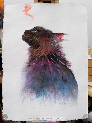 A watercolor painting of a black cat looking upwards, rendered with vibrant purple, pink, blue, and copper brushstrokes on textured white handmade paper. The artwork is shown flat on an easel.