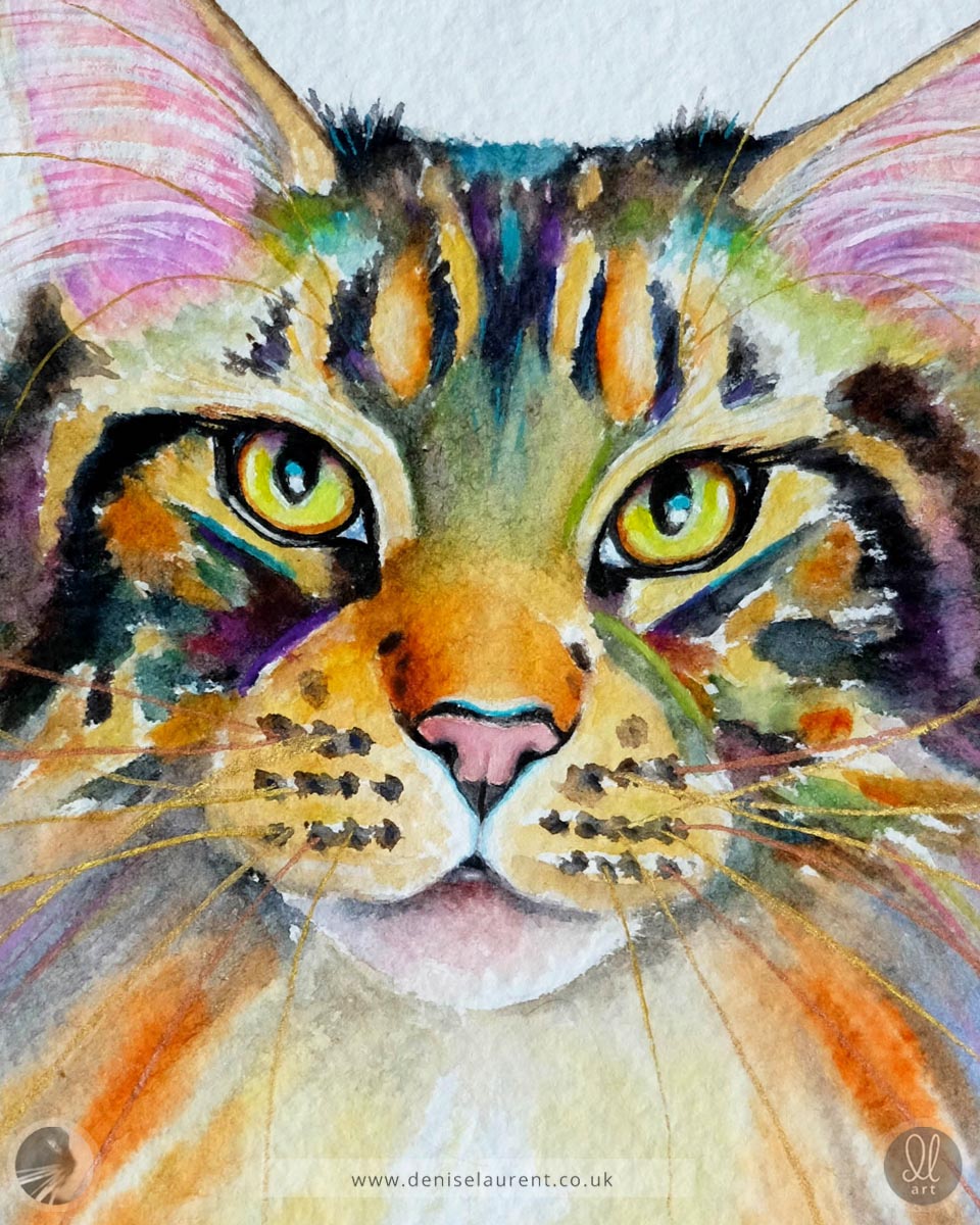 Colorful watercolor painting of a tabby cat's face on textured paper with gold and copper whiskers. Painted on handmade paper with four deckled edges.