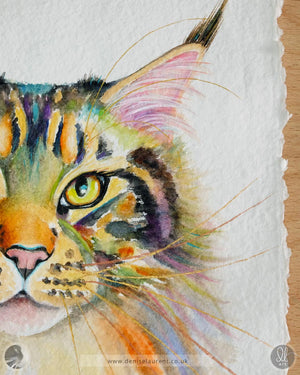 Close up of a watercolor painting of a tabby cat's face on handmade paper showing her gold and copper whiskers and details of the deckled paper edges.