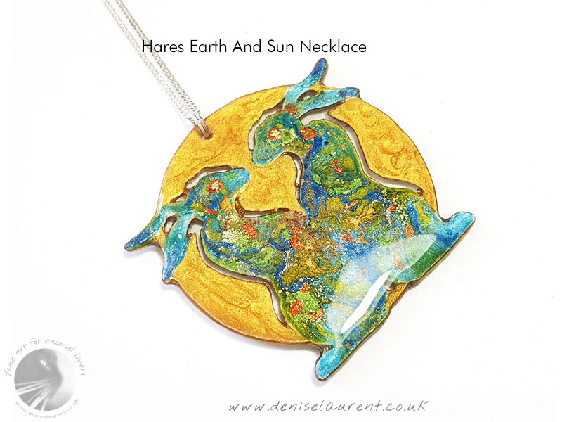 hare sun and moon reversible necklace  2 looks in one. green hares and a gold sun on one side, blue hares and a pearly moon on the other.