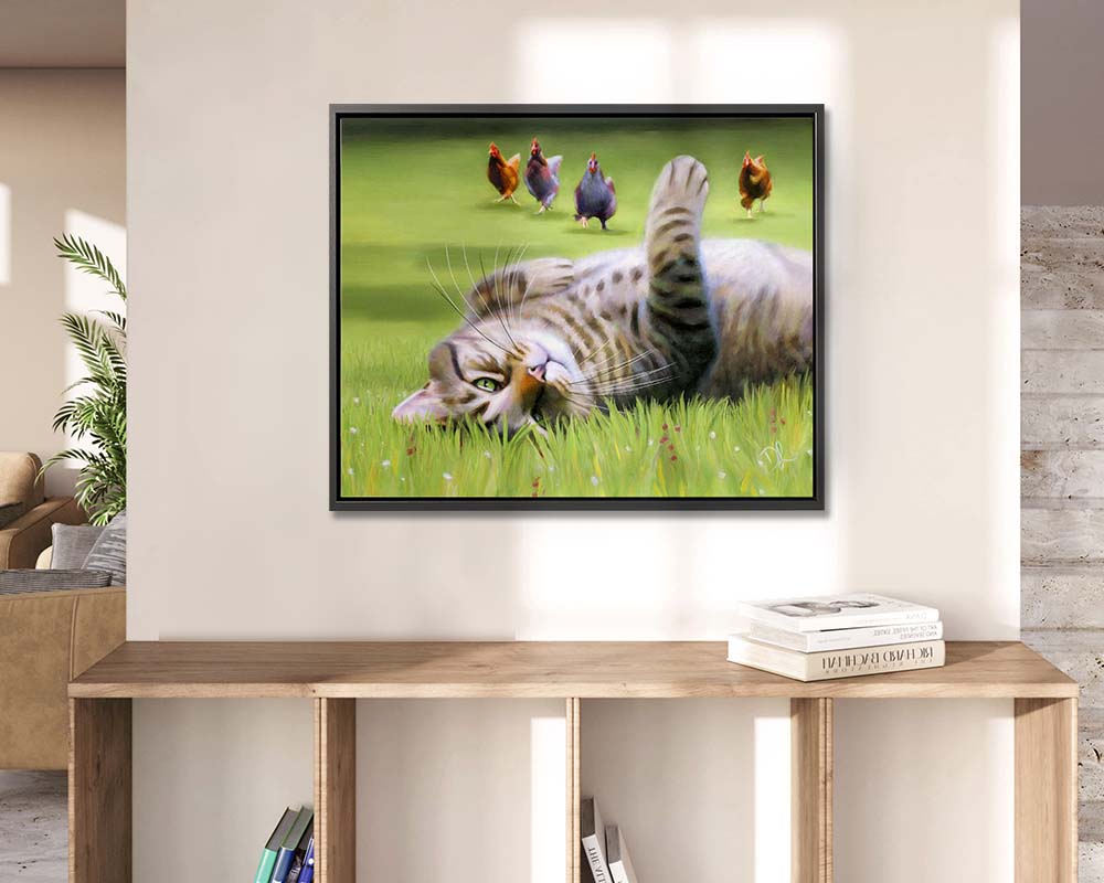 Here Come The Girls - Framed Canvas Print featuring a playful tabby cat rolling in the green grass with chickens in the background.