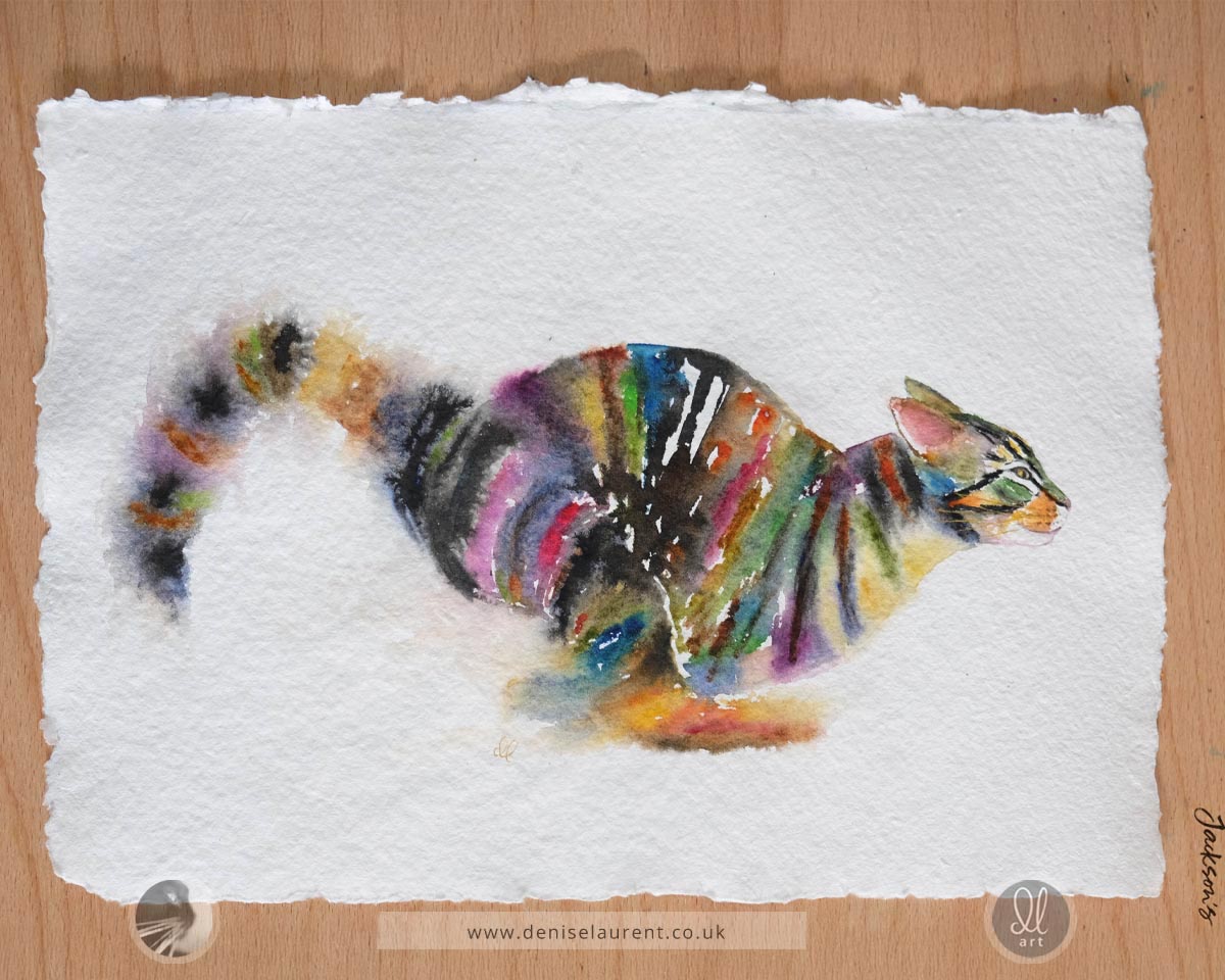 Colorful watercolor painting of a running tabby  cat on handmade textured paper lying on a wood table.
