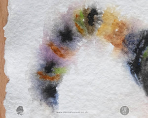 Close-up of a watercolor painting with abstract multicolored shapes on textured white paper.