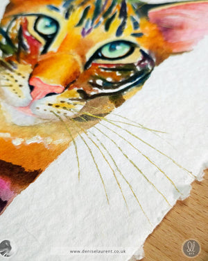 closeup of a watercolour of an oriental tabby on handmade paper showing the gold whisker and the deckled edge of the paper