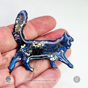a hand made walking cat brooch in blue, black with gold and sparkles.