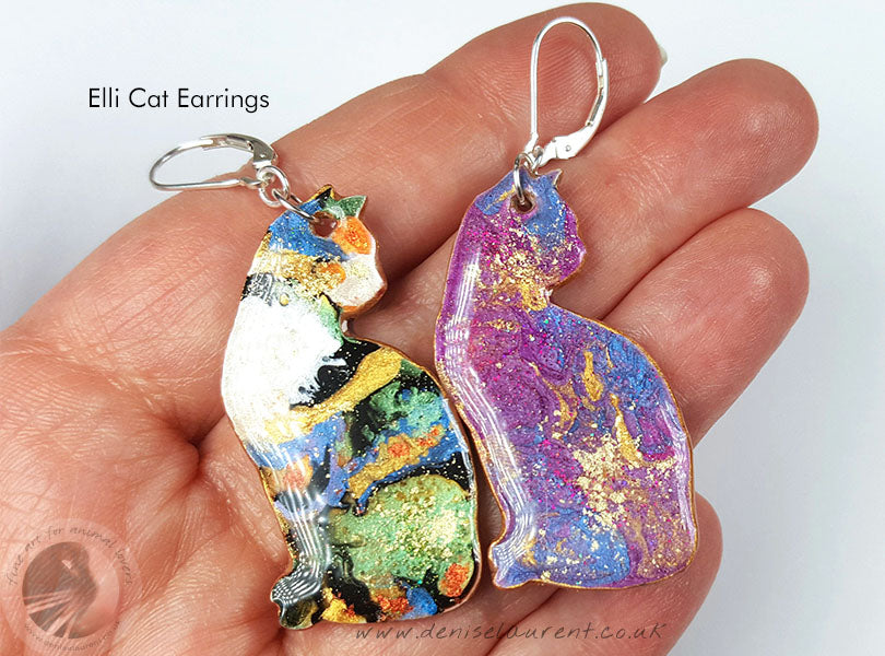 a pair of cat earrings - they are double sided, purple on one side, tabby cat colours on the other. Just turn them around to change your look.