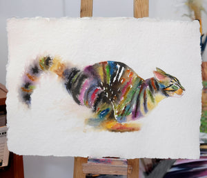 Colorful watercolor painting of a tabby cat running on a textured handmade paper