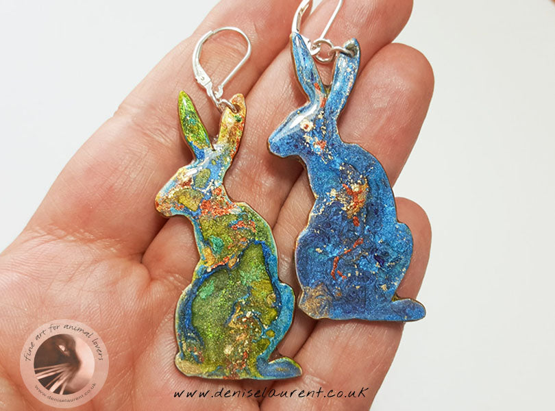a handmade pair of hare earrings - double sided, green on one side blue on the other.