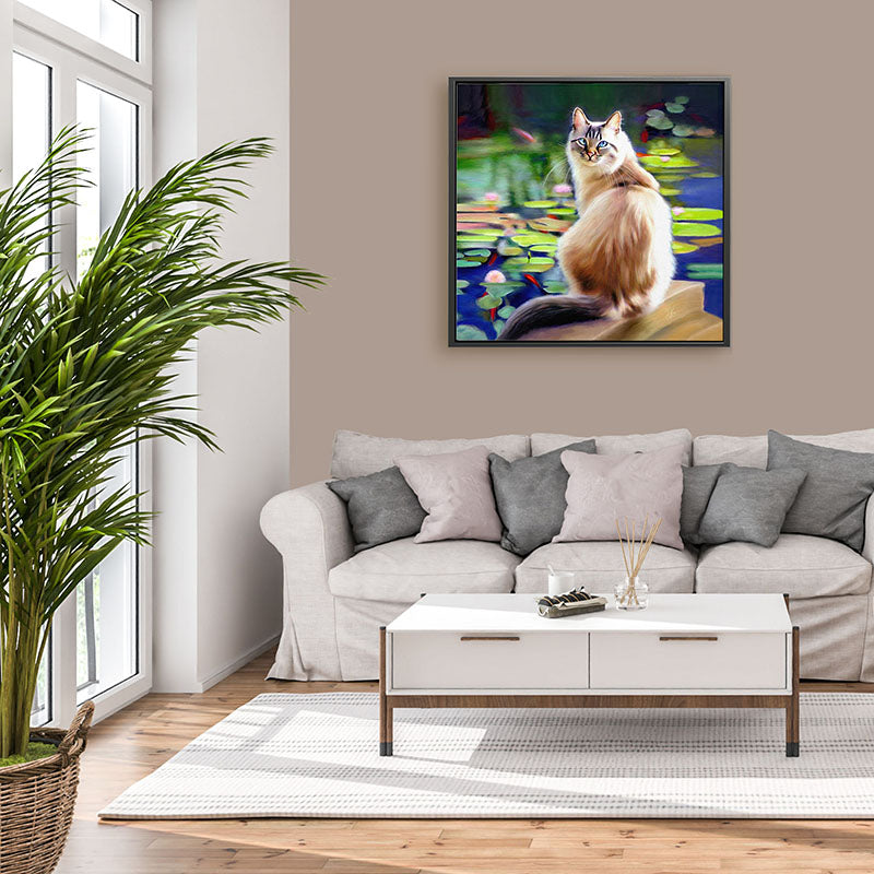 A colourful framed canvas print of a long haired cat sitting by a pond watching the fish swim by. He has lovely blue eyes.